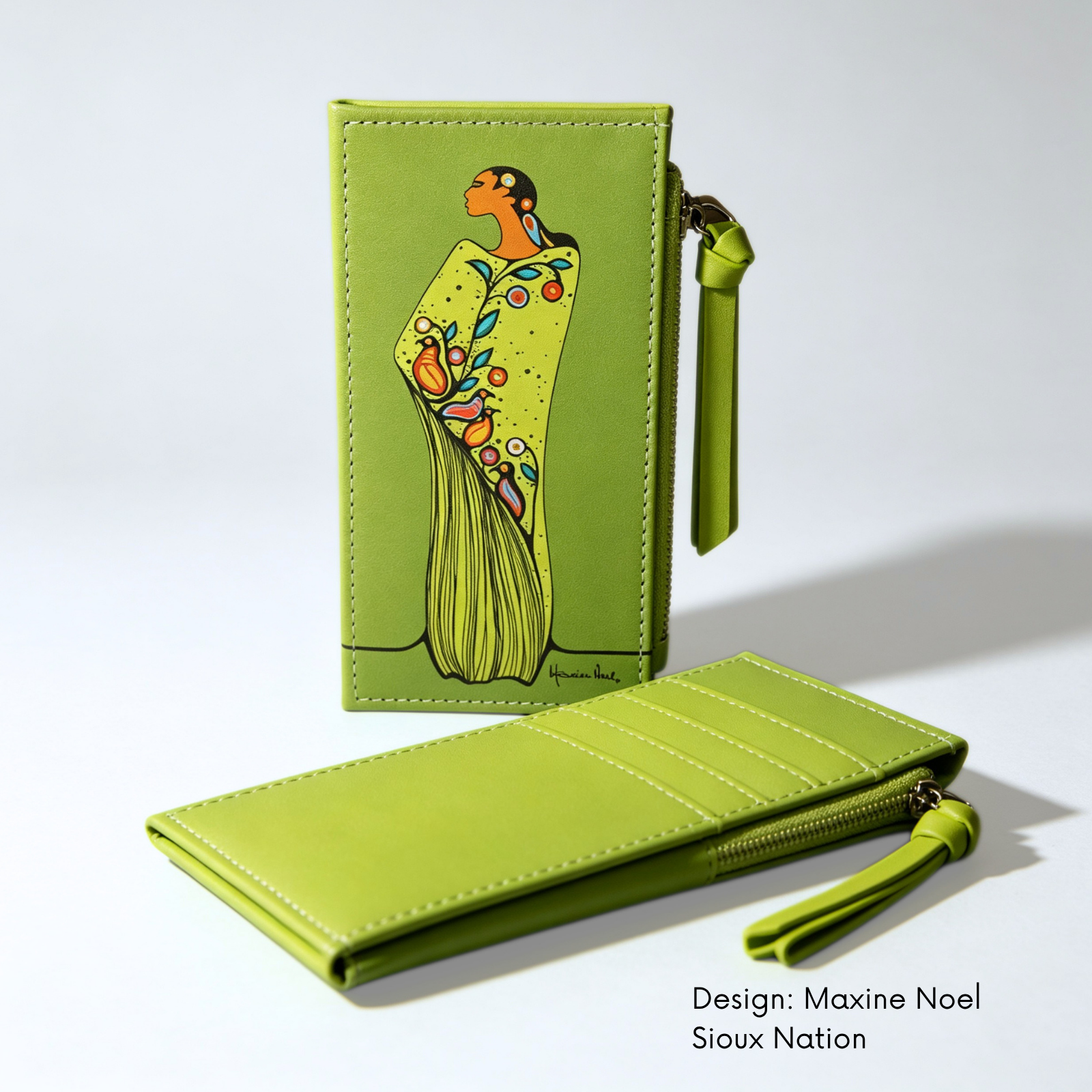 A hand holds a green leather zip-around wallet featuring lime green synthetic leather card holder featuring Maxine Noel’s Spirit of the Woodlands artwork