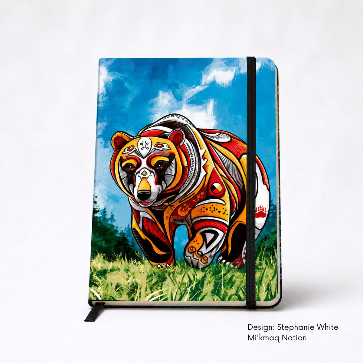 Hardcover journal featuring a colourful bear walking forward through grass, its body filled with Mi’kmaq symbols including a medicine wheel and double curls.