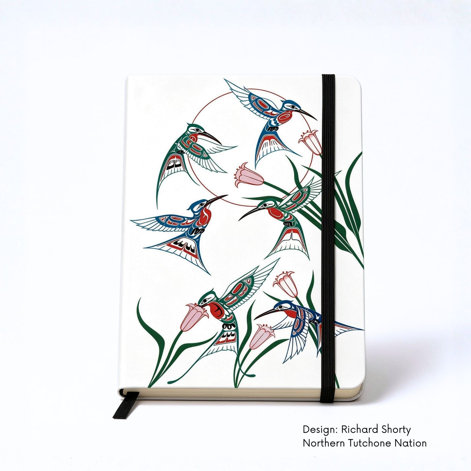 White hardcover journal featuring six stylized hummingbirds in red, blue and green flying among delicate pink flowers and long green leaves.
