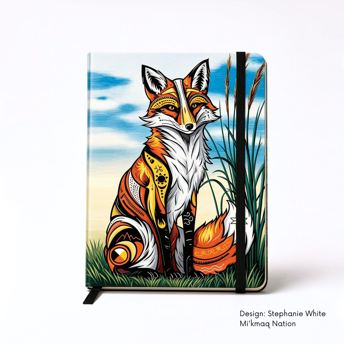 Hardcover journal featuring a seated red fox filled with bold red, yellow, black and white symbols, surrounded by grass and tall reeds beneath a blue sky.