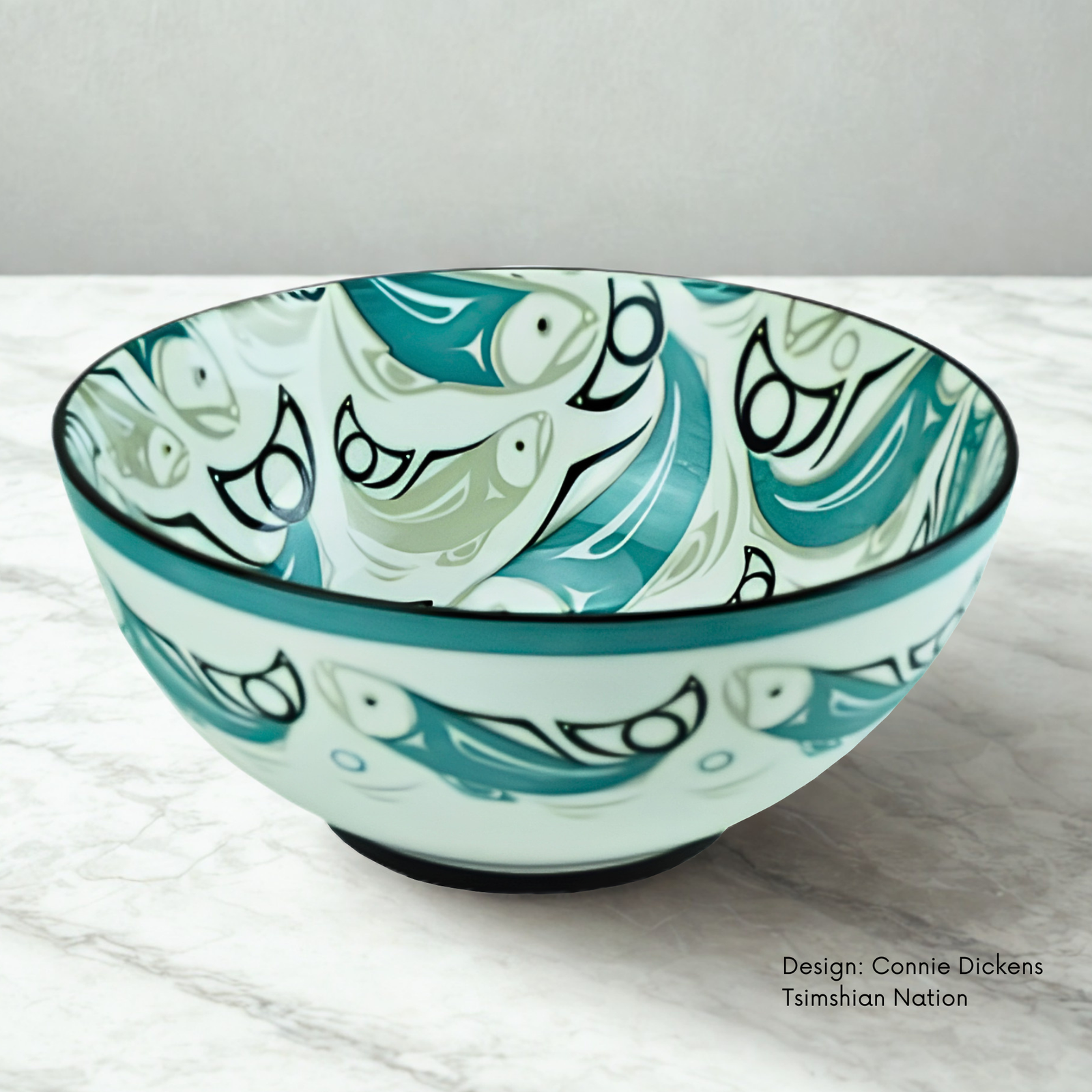 Large porcelain bowl featuring Salmon artwork by Coast Tsimshian artist Connie Dickens, with flowing turquoise forms on white porcelain.