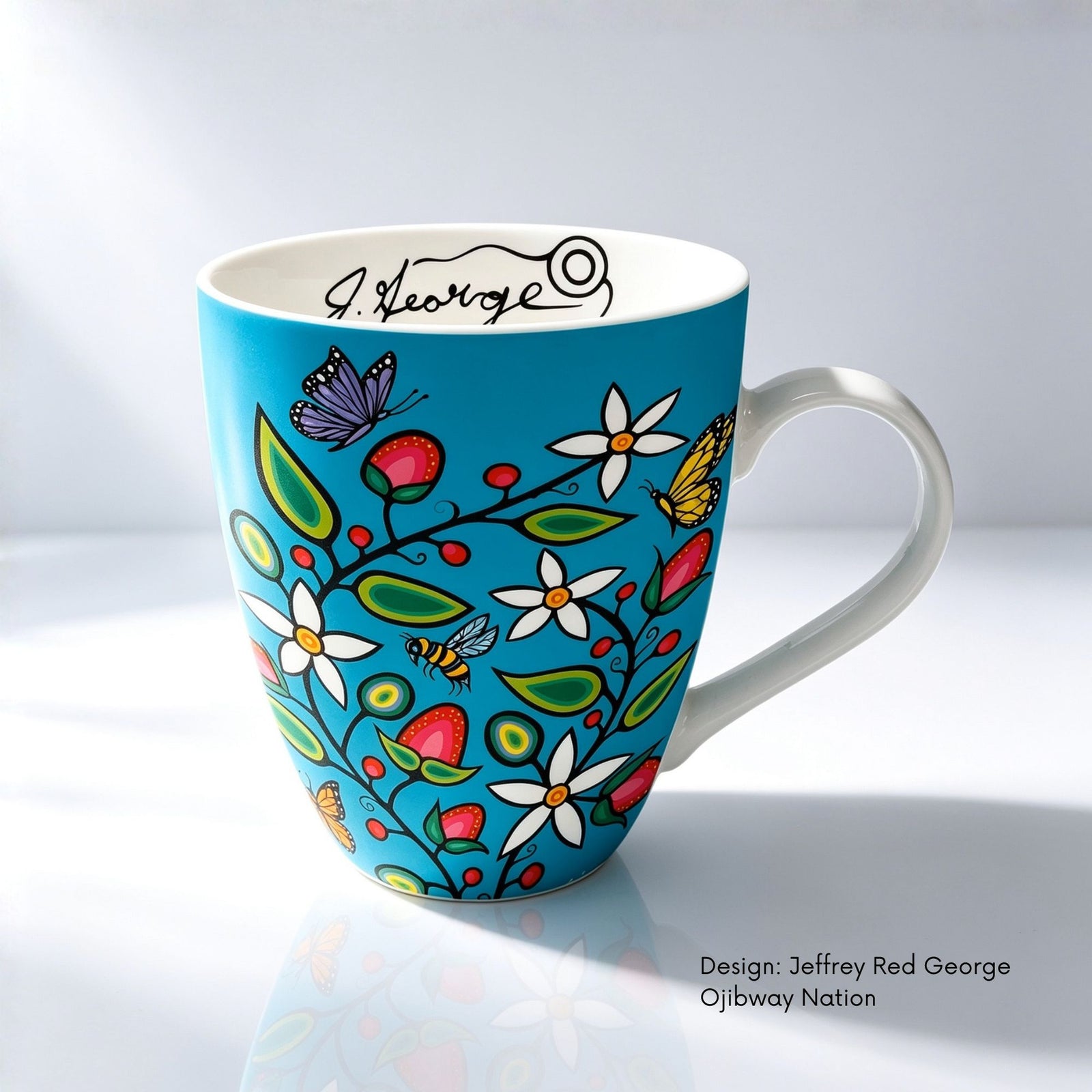 Fine bone china mug featuring Berry Garden artwork by Ojibway artist Jeffrey Red George, with flowers, berries, butterflies and a bee.